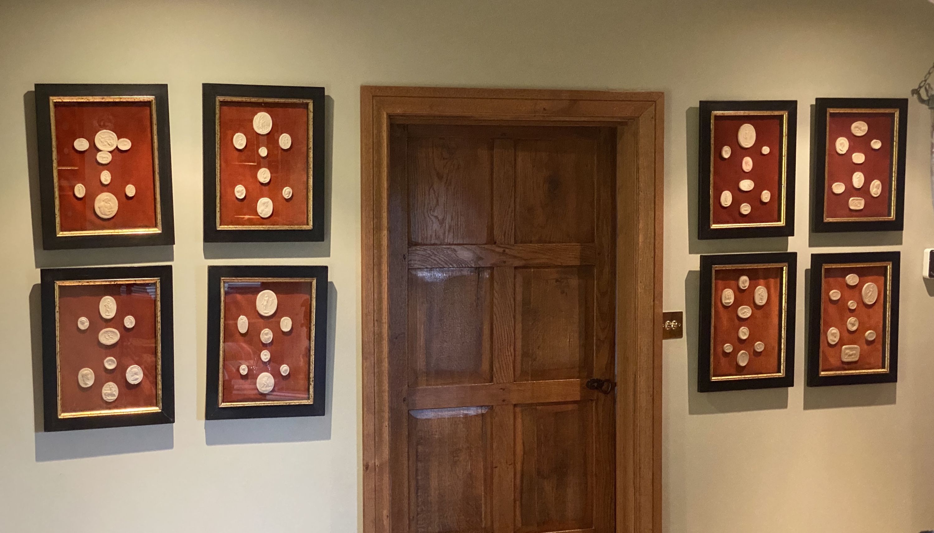 A collection of thirty four framed reproduction plaster intaglios, on velvet backing with parcel gilt ebonised frames, overall 45 x 35cm